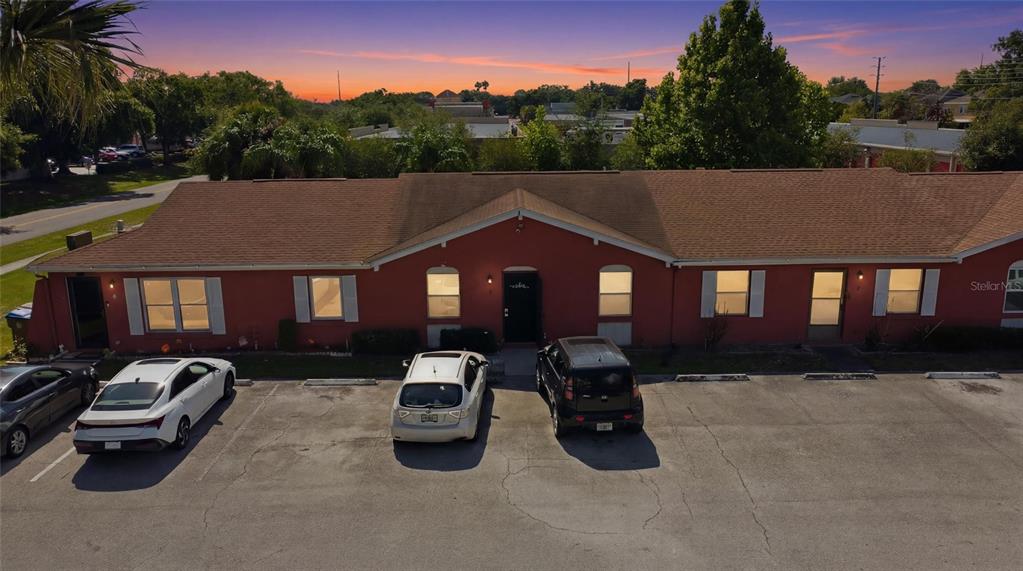 An aerial view of a single-story red commercial building with a parking lot in front — 2 E LAS PALMAS WAY, KISSIMMEE, FL