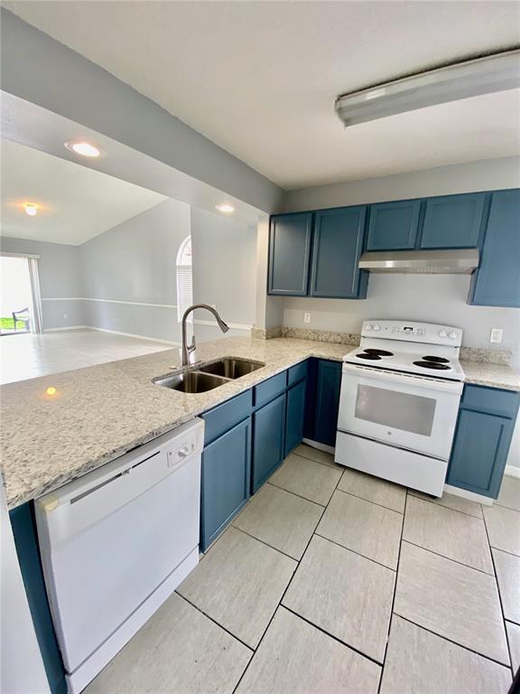 A kitchen features blue cabinets, granite countertops, a white dishwasher, and a white range — 2298 SANTA LUCIA STREET, KISSIMMEE, FL