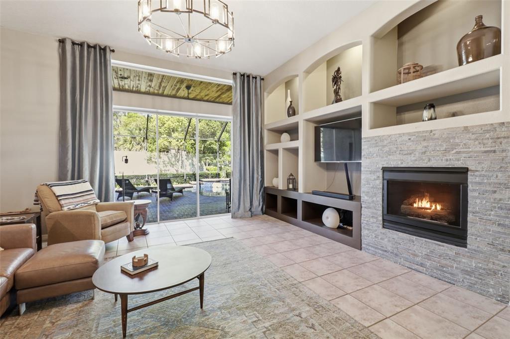 A kitchen with dark gray cabinets, granite countertops, a central island, and stainless steel appliances — 3629 WHISTLING LANE, LAND O LAKES, FL