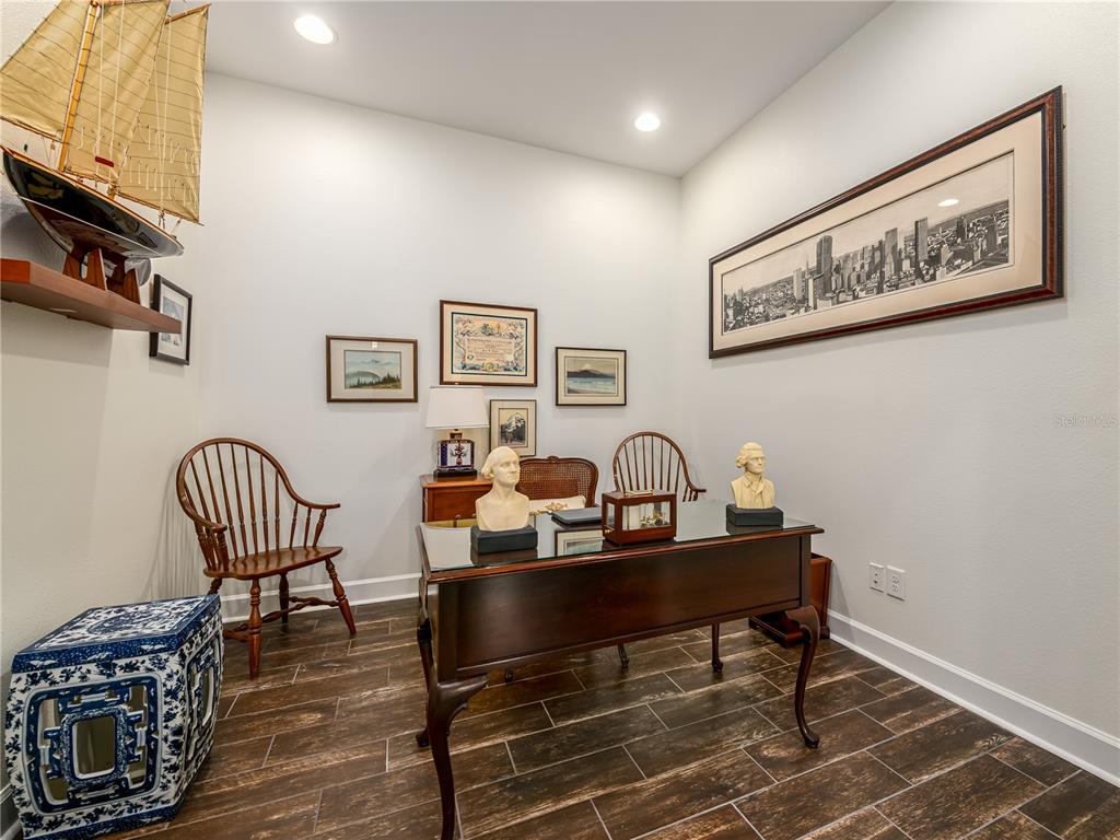 A home office features a dark wood desk, two wooden chairs, and several framed wall pictures — 4521 BARLETTA COURT, WESLEY CHAPEL, FL