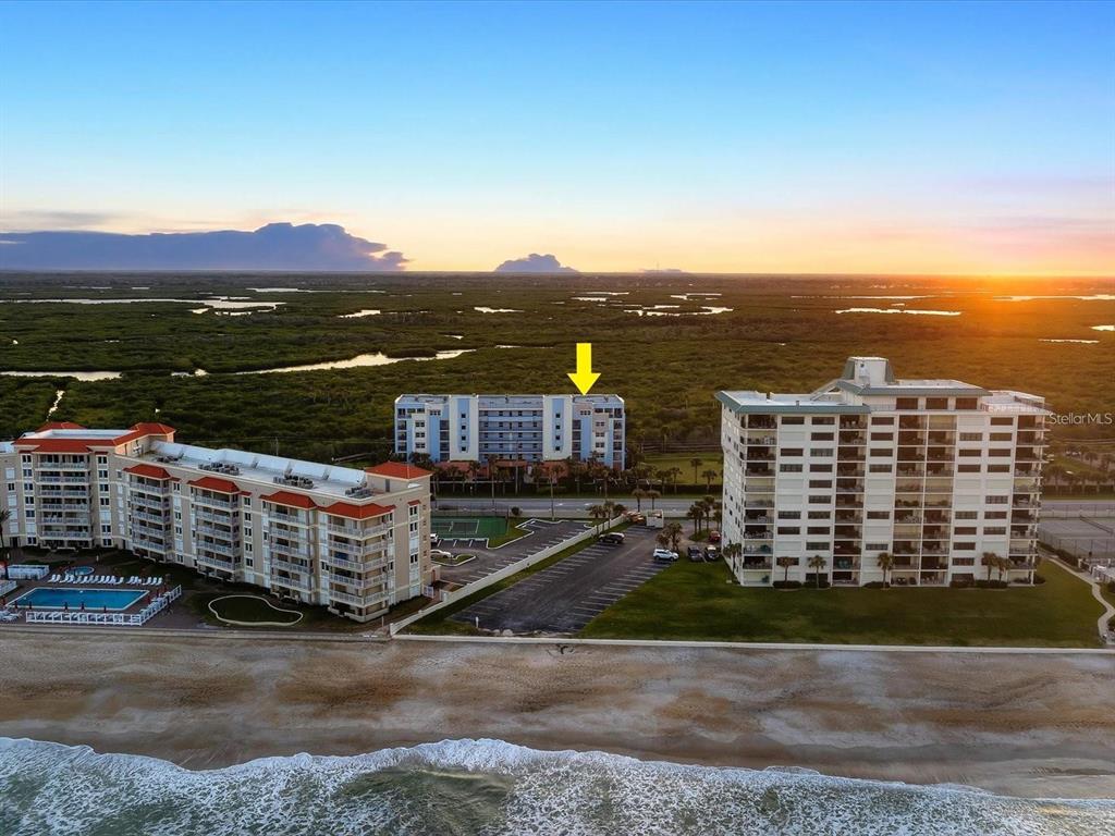 An aerial view shows three beachfront apartment buildings with a yellow arrow pointing to the center — 5300 SOUTH ATLANTIC AVENUE UNIT 19406, NEW SMYRNA BEACH, FL