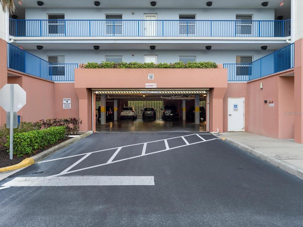 A ground-level parking garage entrance is located beneath the balconies of a multi-story building — 5300 SOUTH ATLANTIC AVENUE UNIT 19406, NEW SMYRNA BEACH, FL