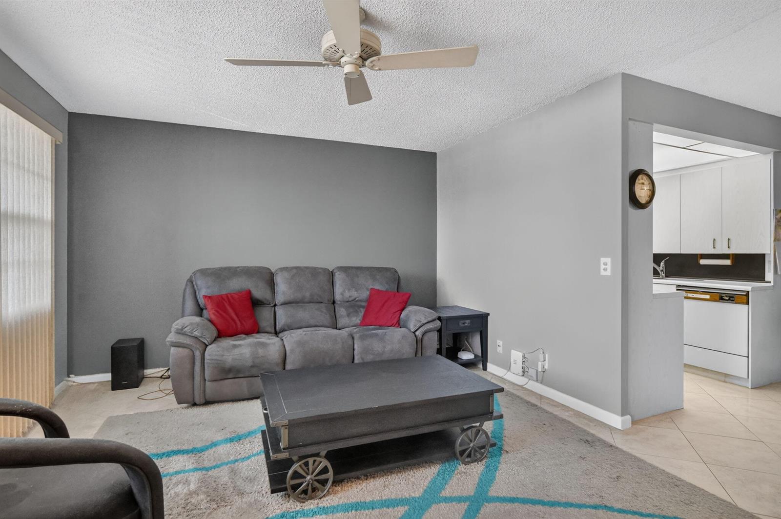 A living room features a gray sofa, a coffee table with wheels, and a ceiling fan — 3090 Wolverton E, Boca Raton FL 33434, BOCA RATON, FL