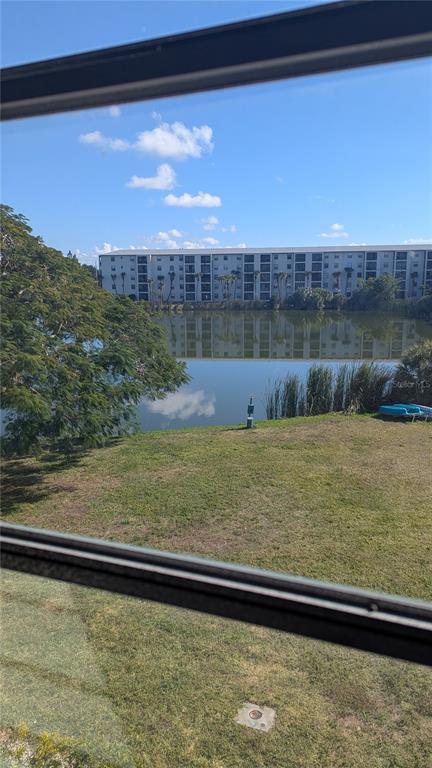 A view from a window overlooking a grassy lawn, a pond, and an apartment building — 4087 LAKE BAYSHORE DRIVE UNIT 312, BRADENTON, FL