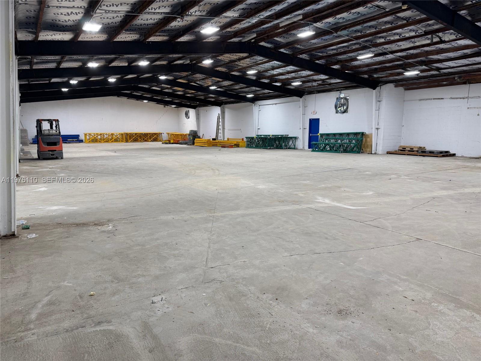 A large, open warehouse space features a concrete floor, exposed steel beams, and industrial lighting — 1201 E University Ave, Gainesville FL 32641, GAINESVILLE, FL