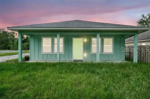 A single-story house with light green vertical siding and a covered front porch — 40091 OAKRIDGE DRIVE, LADY LAKE, FL