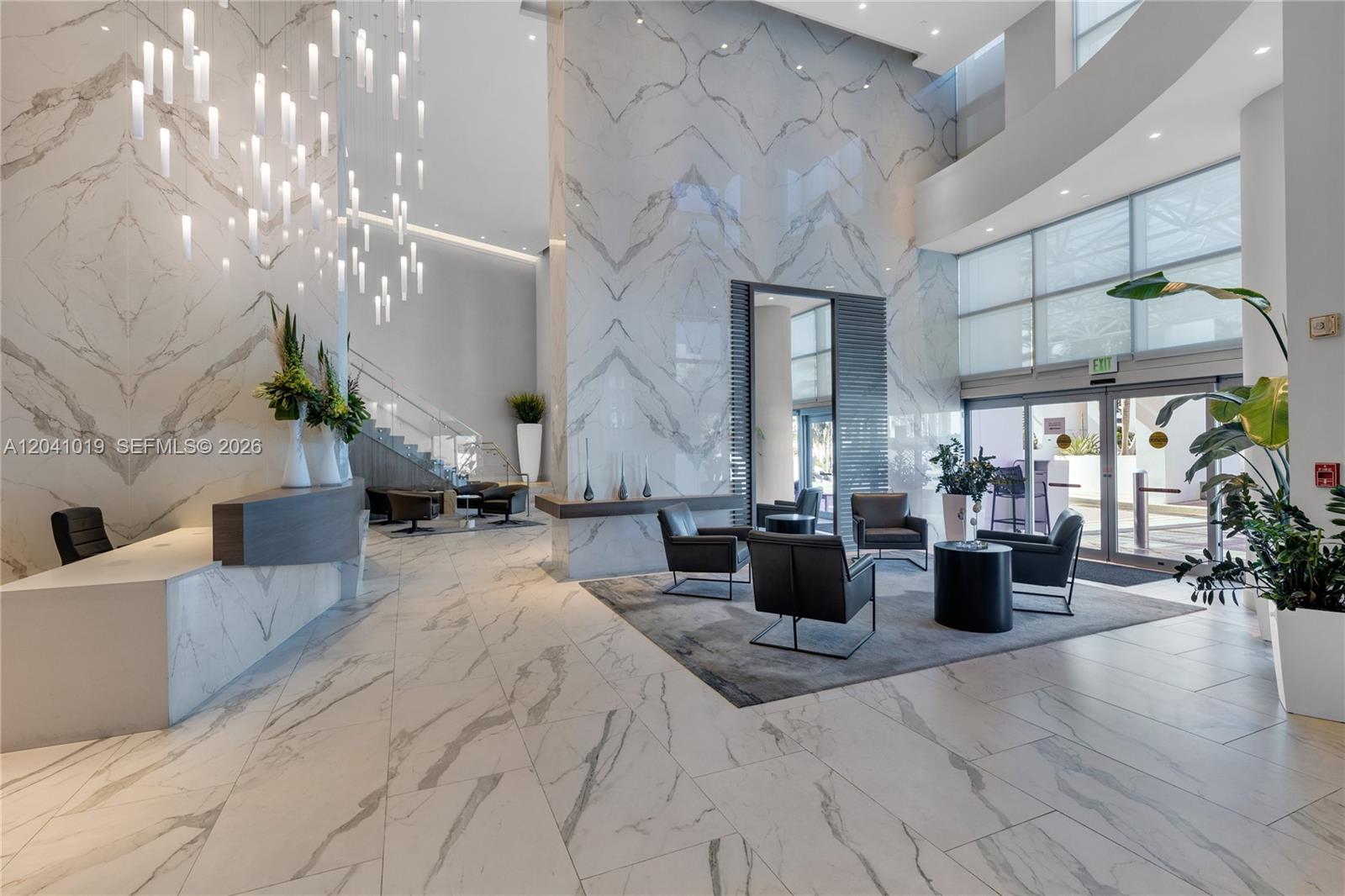 A modern lobby features marble walls, tile flooring, a reception desk, and a seating area — 3535 S OCEAN DR # 705, Hollywood FL 33019, HOLLYWOOD, FL