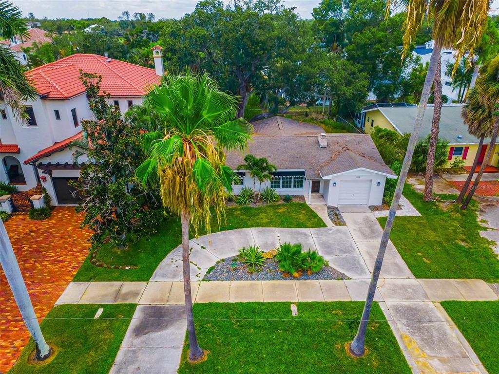 An aerial view shows a single-story house with a white exterior, garage, and palm trees — 910 SNELL ISLE BOULEVARD NE, ST PETERSBURG, FL