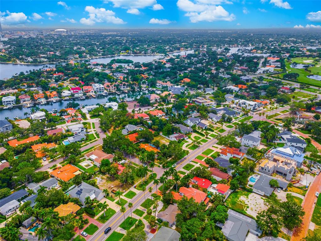 An aerial view shows a residential neighborhood with houses, palm trees, and a winding canal — 910 SNELL ISLE BOULEVARD NE, ST PETERSBURG, FL