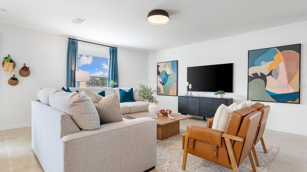 A living room features a light gray sectional sofa, two leather chairs, and abstract wall art — 5422 CROWN POINT ROAD, KISSIMMEE, FL