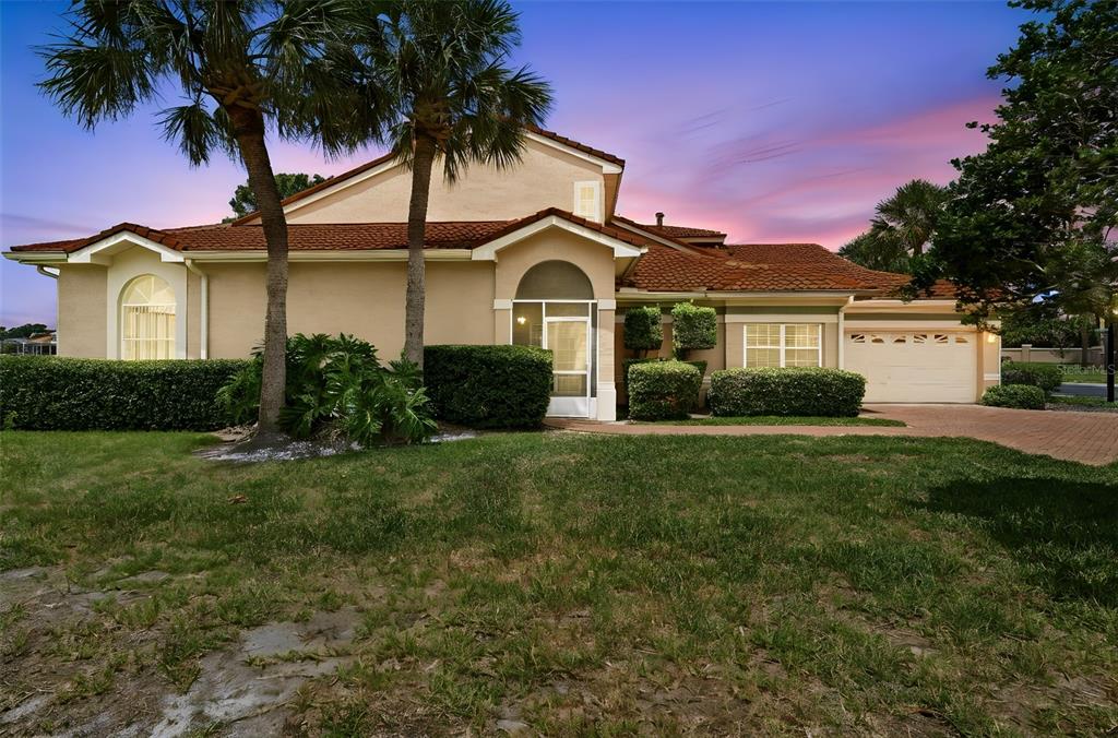 A single-story house with a tiled roof, beige stucco walls, and a paved driveway — 4850 WATERVISTA DRIVE, ORLANDO, FL