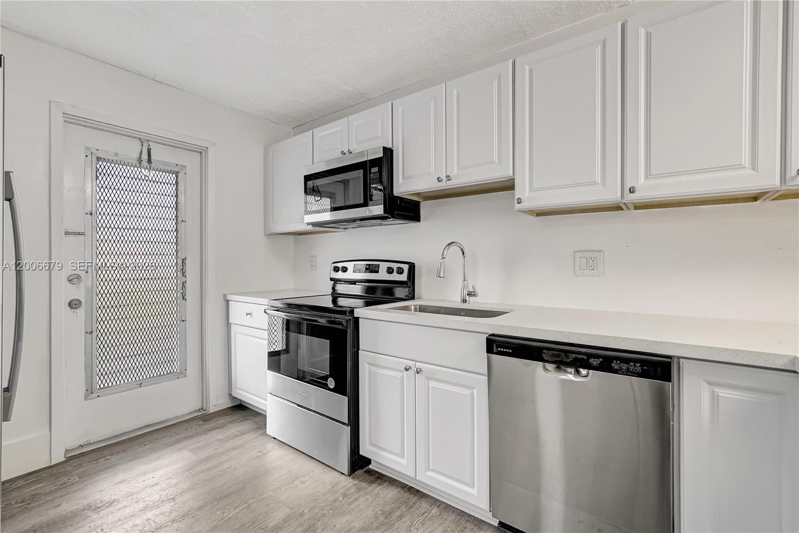 A kitchen features white cabinets, stainless steel appliances, a sink, and light-colored countertops — 4800 Hillcrest Ln # 207, Hollywood FL 33021, HOLLYWOOD, FL