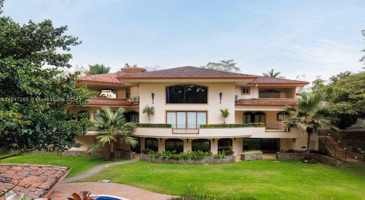 A large multi-story stucco house with a red tile roof overlooks a grassy backyard — San Rafael Escazu San Jose Prov. Escazu, CR, CR