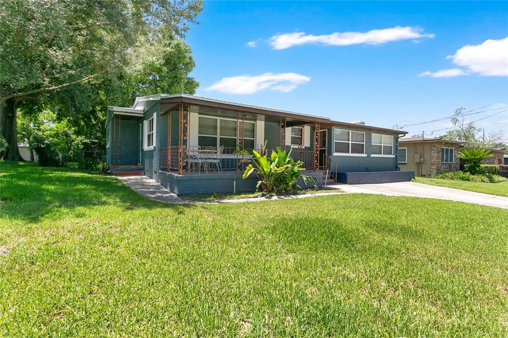 A single-story house with a dark green brick exterior and a covered front porch — 2418 E JERSEY AVENUE, ORLANDO, FL