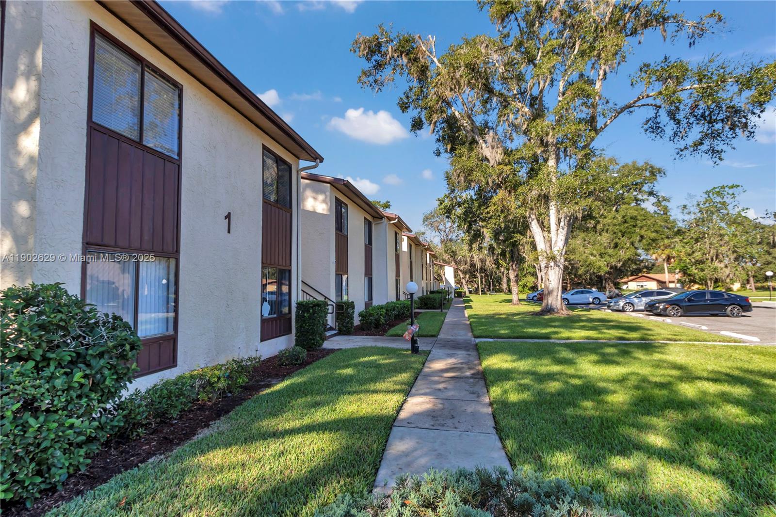 A two-story apartment building exterior features a sidewalk, green lawn, and a parking lot — 737 Midway Dr # B, Ocala FL 34472, OCALA, FL
