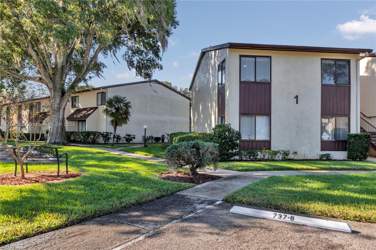 A two-story apartment building with beige stucco walls and brown trim sits near a lawn — 737 Midway Dr # B, Ocala FL 34472, OCALA, FL