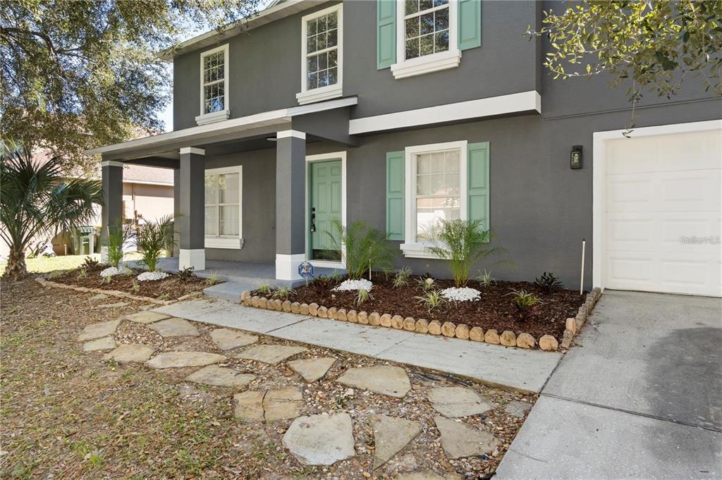 A two-story house with gray siding, a light green front door, and a stone walkway — 1893 VALE DRIVE, CLERMONT, FL