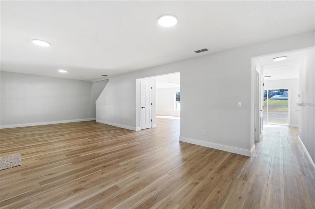 An interior view of a room with light wood-look flooring and white walls — 1893 VALE DRIVE, CLERMONT, FL