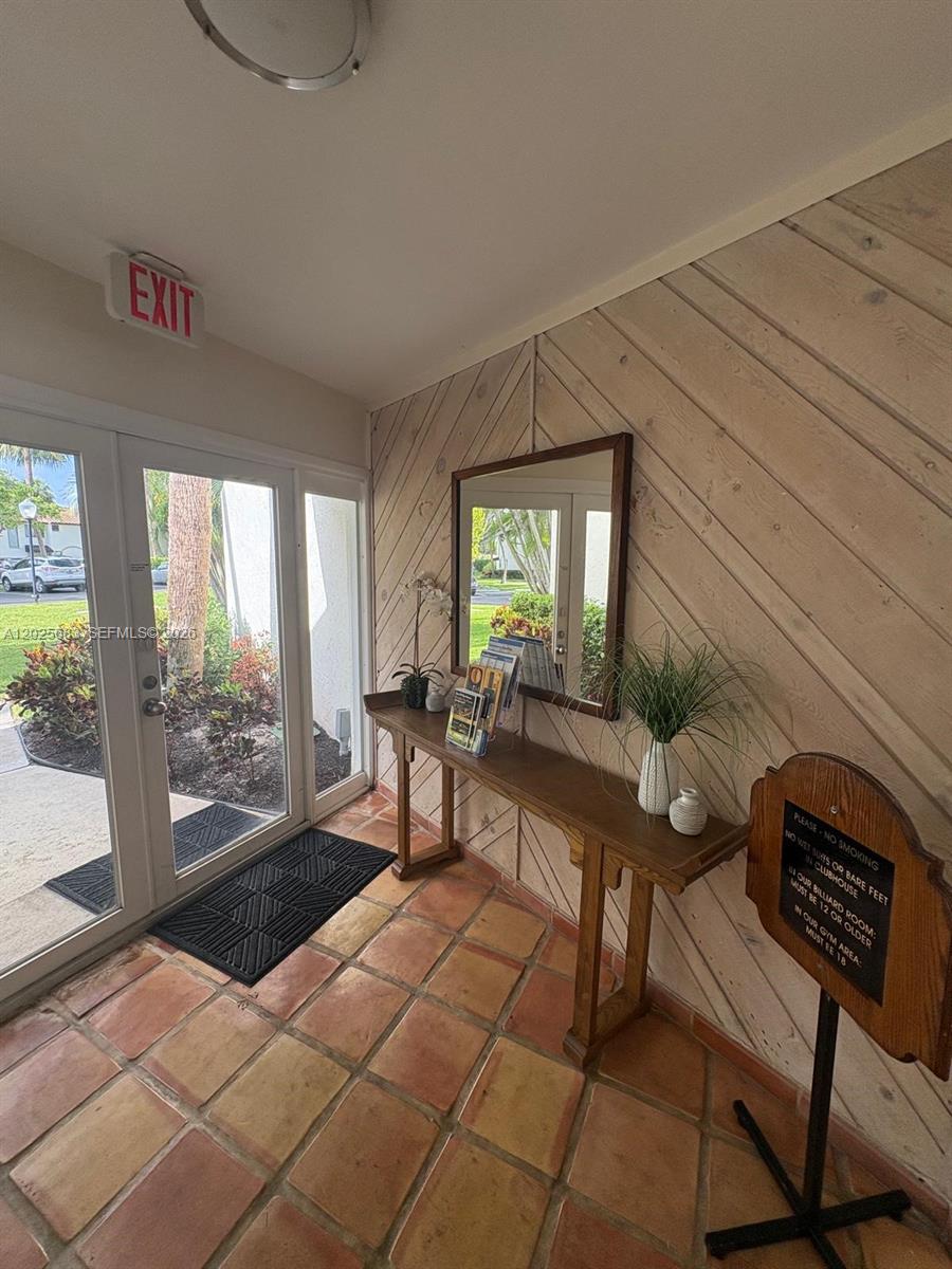 A bedroom features a bed with patterned bedding, a desk, and a balcony with railings — 7200 NW 2nd Ave # 1180, Boca Raton FL 33487, BOCA RATON, FL