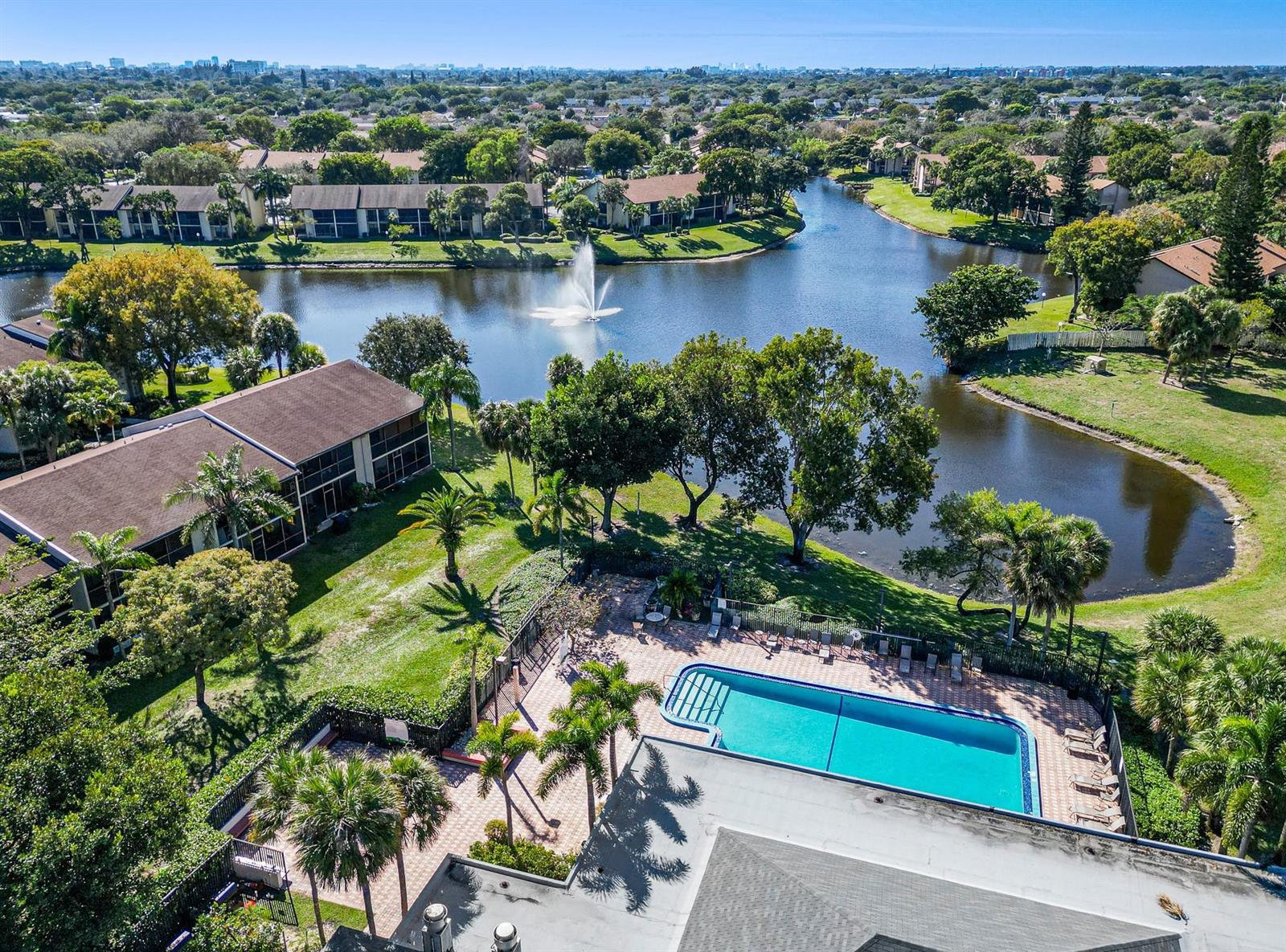 An aerial view of a swimming pool, a lake with a fountain, and surrounding residential buildings — 1230 S Military Trail # 2011, Deerfield Beach FL 33442, DEERFIELD BEACH, FL