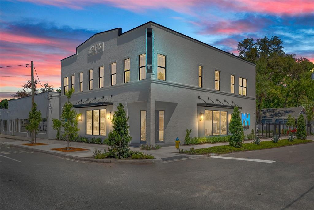 A two-story white brick commercial building stands on a corner lot at dusk — 902 E CURTIS STREET UNIT 1, TAMPA, FL