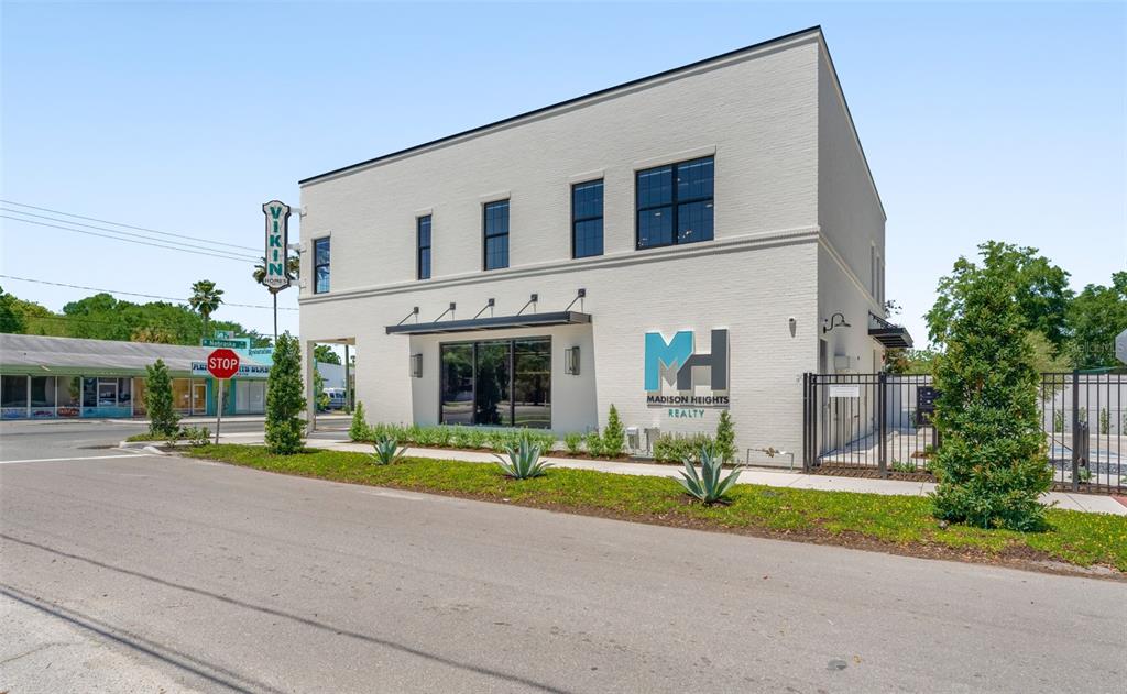 A two-story white brick commercial building with a Madison Heights Realty sign and landscaping — 902 E CURTIS STREET UNIT 1, TAMPA, FL