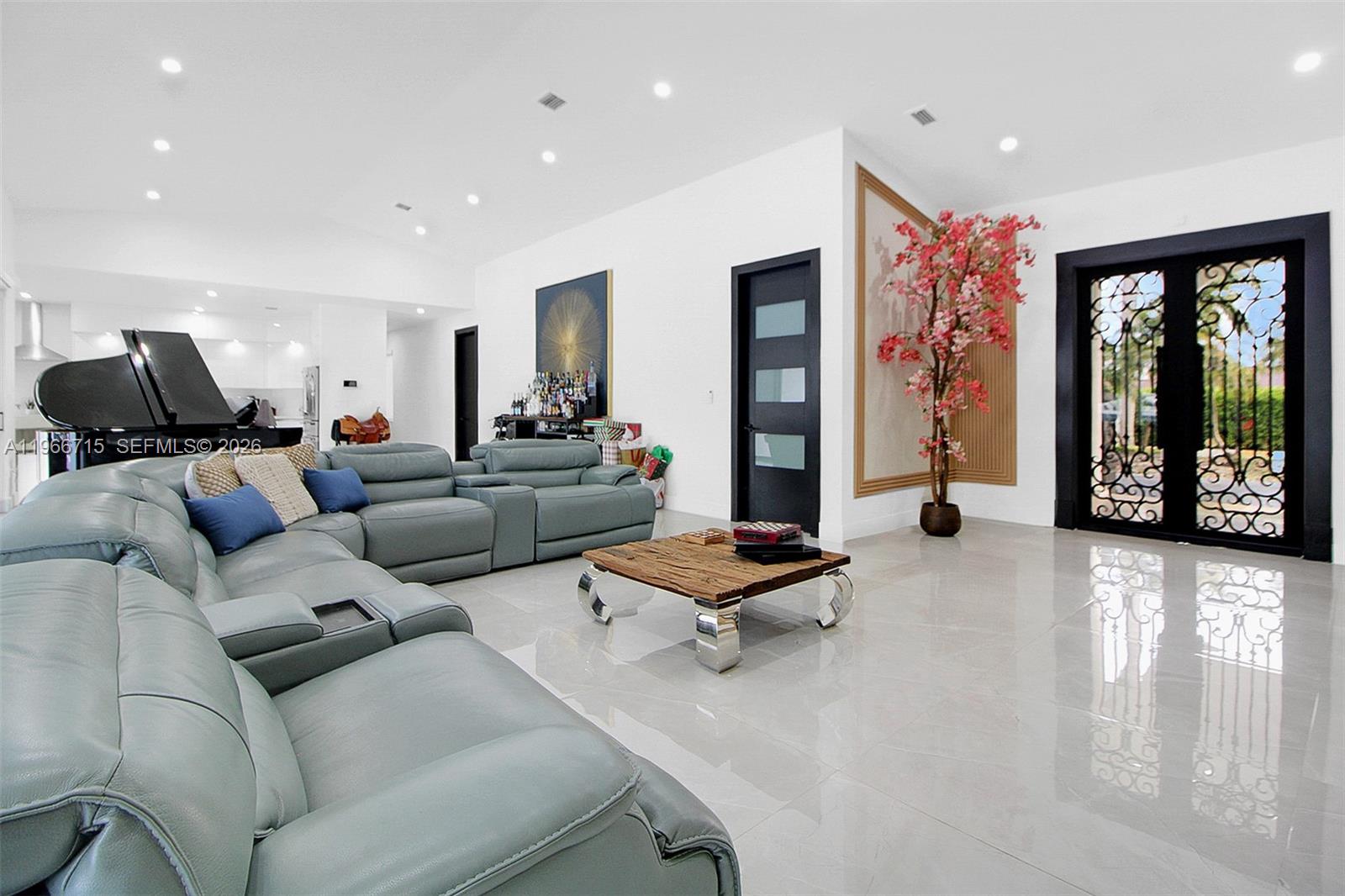A modern living room features a large gray sectional sofa, a wooden coffee table, and a piano — 2600 SW 128th Ave, Miami FL 33175, MIAMI, FL