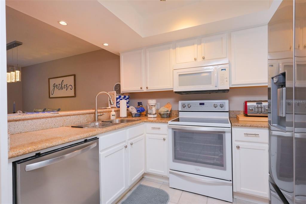 A kitchen with white cabinets, stainless steel appliances, and a beige countertop — 2135 WATER MANIA COURT, KISSIMMEE, FL