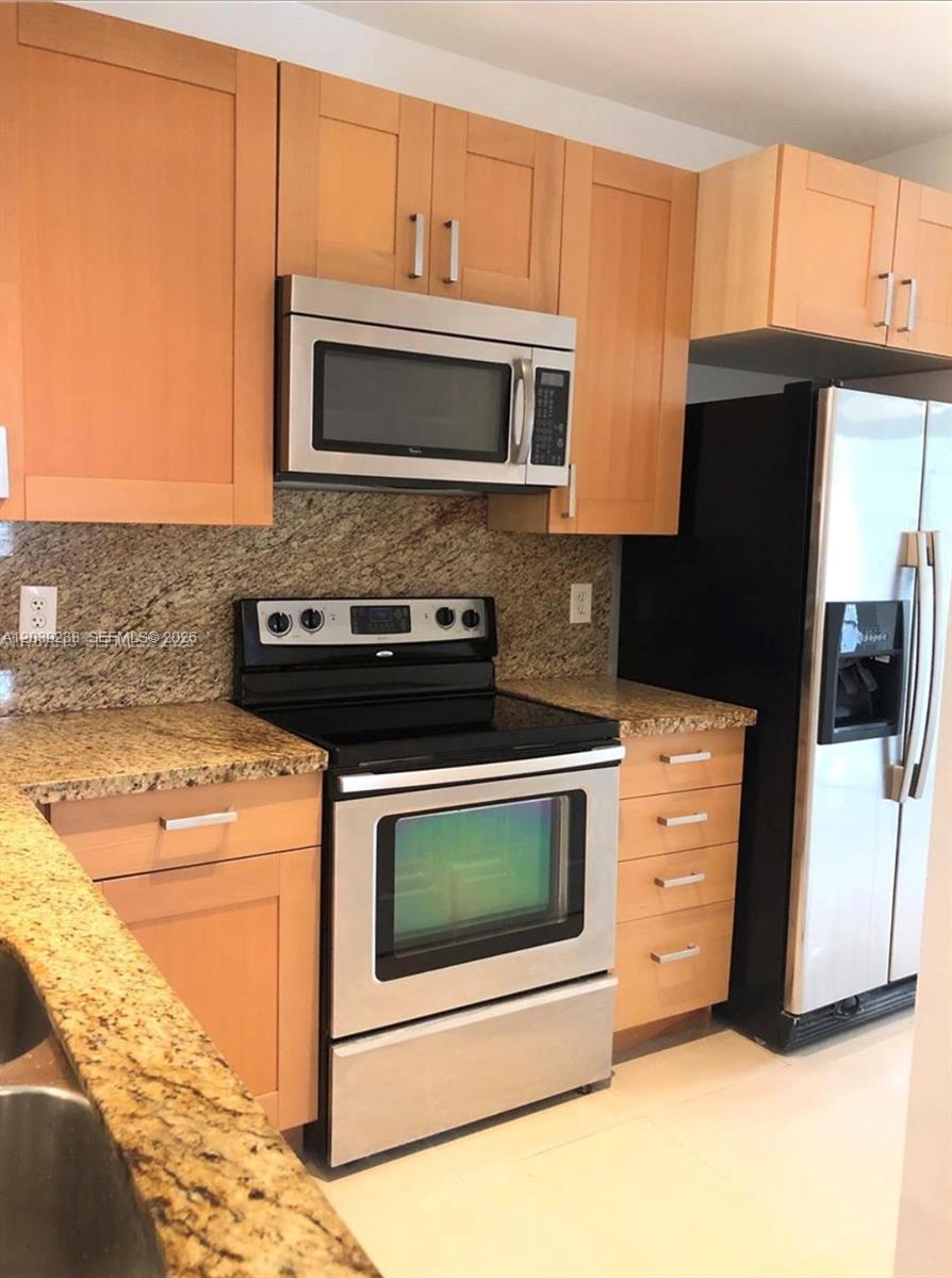 A kitchen features light wood cabinets, granite countertops, and stainless steel appliances — 16231 Emerald Cove Rd # 0, Weston FL 33331, WESTON, FL