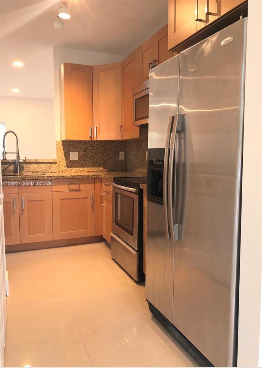 A kitchen features light wood cabinets, stainless steel appliances, and granite countertops — 16231 Emerald Cove Rd # 0, Weston FL 33331, WESTON, FL