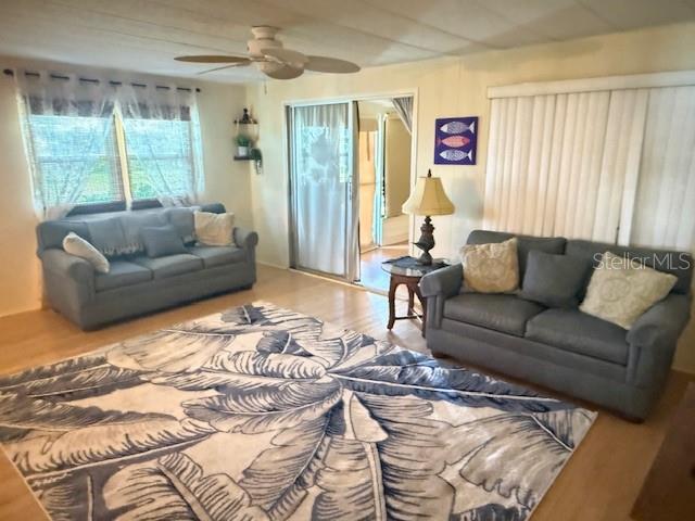 A living room features two gray sofas, a patterned area rug, and a ceiling fan — 184 INDEPENDENCE AVENUE UNIT 8, PALM HARBOR, FL