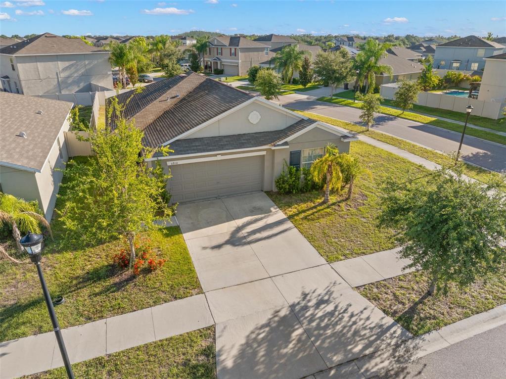 An aerial view shows a single-story suburban house with a concrete driveway and attached garage — 6810 TRENT CREEK DRIVE, SUN CITY CENTER, FL
