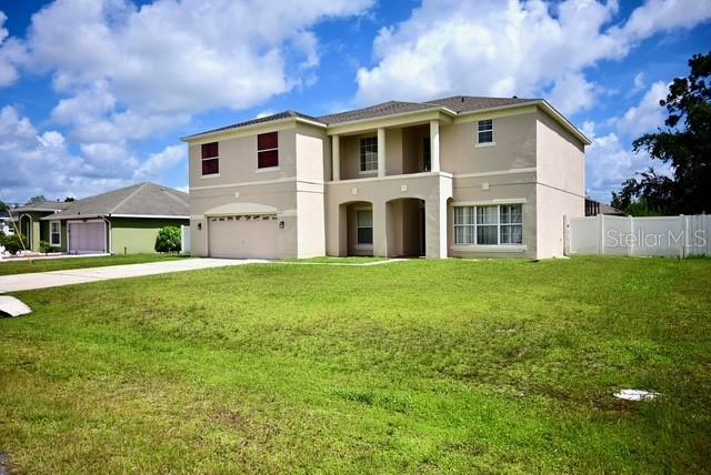 A two-story beige house with a garage and a large front lawn — 632 BITTERN COURT, KISSIMMEE, FL