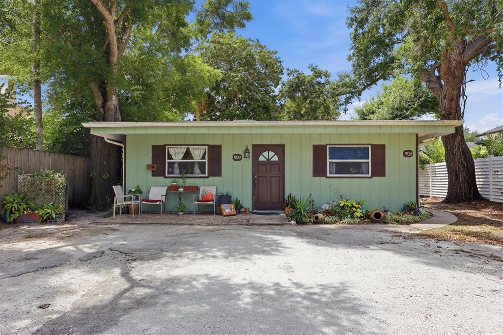 A single-story green house with brown shutters and a front patio sits on a lot — 1824 WEBBER STREET, SARASOTA, FL