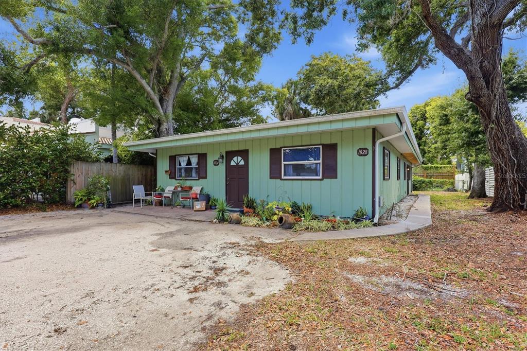 A light green single-story house with brown shutters and a patio sits on a lot — 1824 WEBBER STREET, SARASOTA, FL