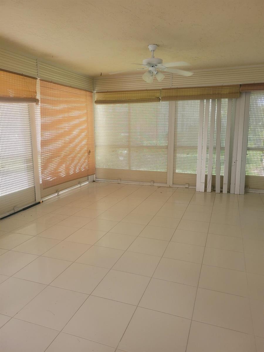 A sunroom with white tile floors, a ceiling fan, and bamboo shades over large windows — 3345 Perimeter Drive # 1311, FL 33467, FL