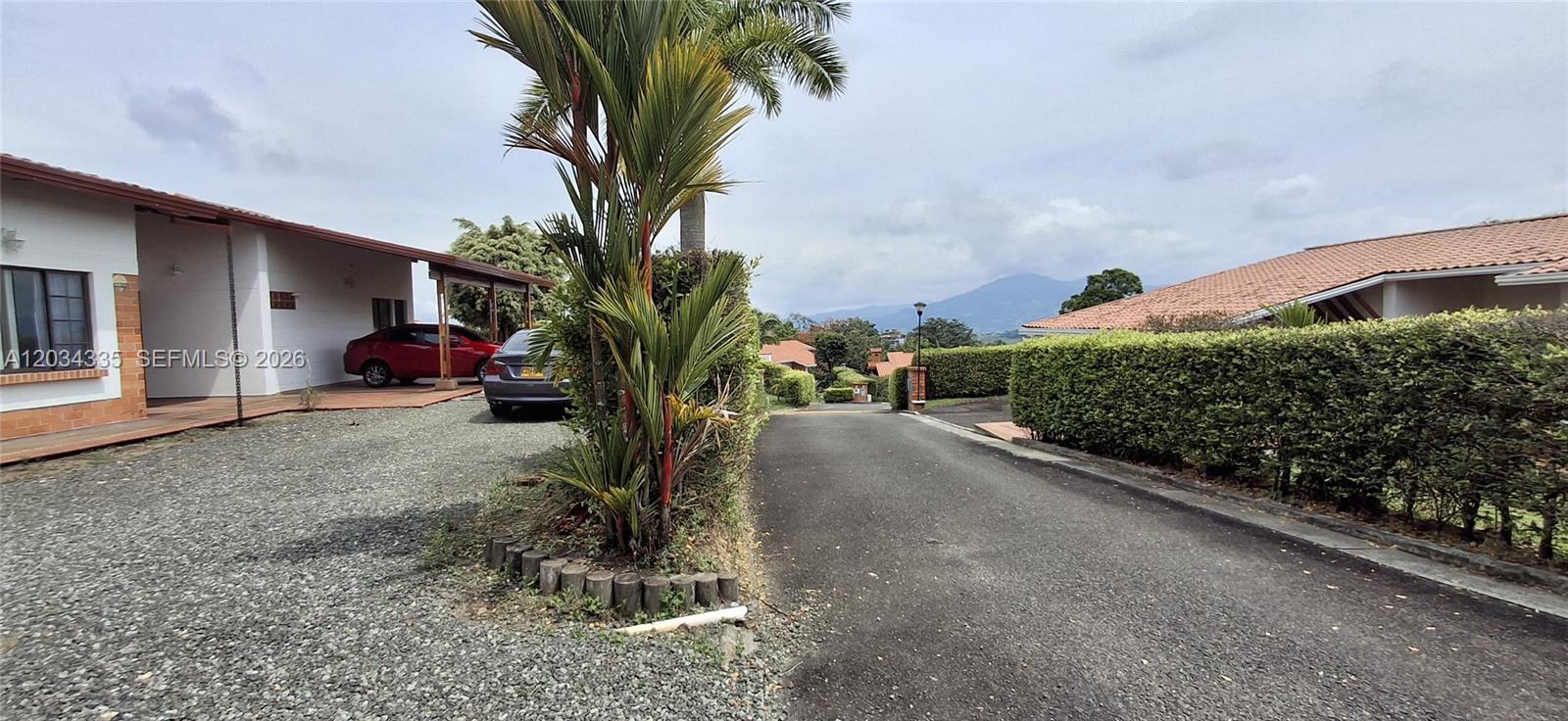 A paved driveway leads past a house with a gravel parking area and landscaping — Casa Campestre Via Condina Casa 19, FL 0, FL
