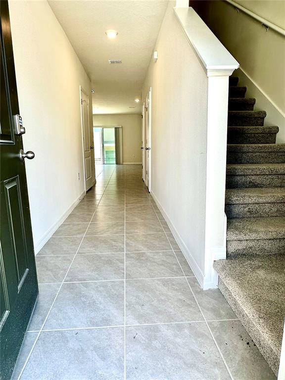 A tiled entryway leads to a hallway with a staircase on the right — 2349 PENGUIN BOULEVARD, DAVENPORT, FL