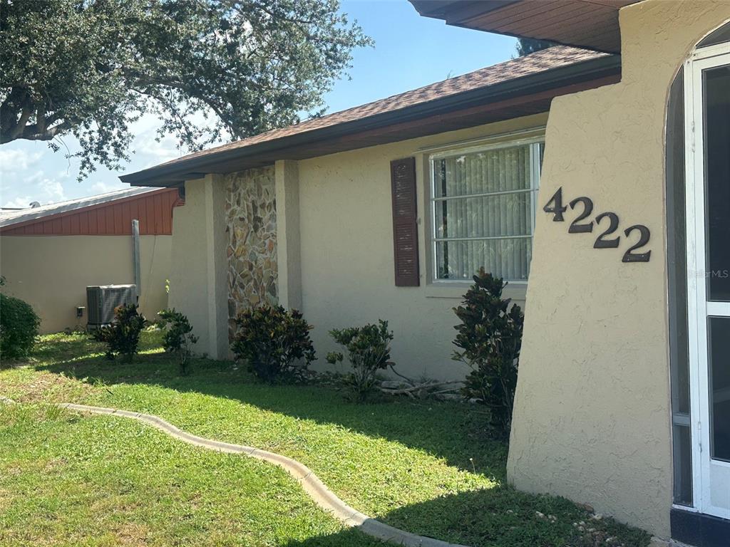 The exterior of a single-story house features a stone accent wall and a house number — 4222 COCKRELL STREET, PORT CHARLOTTE, FL