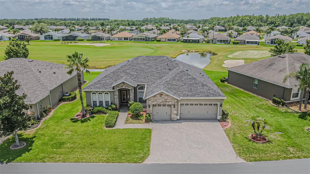 An aerial view shows a single-story house with a stone facade, garage, and paved driveway — 10404 BELMULLET DRIVE, SAN ANTONIO, FL