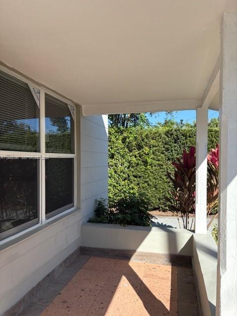 A covered porch with tiled flooring, white siding, and a view of outdoor greenery — 752 NW 24th Ct # 1, Miami FL 33125, MIAMI, FL