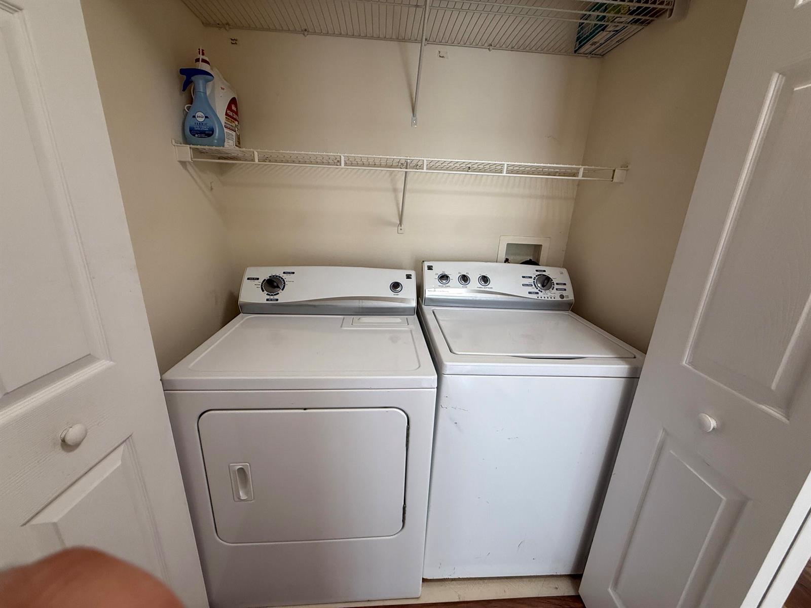 A laundry closet contains a white top-loading washing machine and a matching dryer — 1979 Summer Club Drive # 213, FL 32765, FL