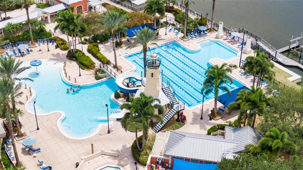 An aerial view of a resort-style swimming pool complex featuring a lighthouse and water slide — 638 MANNS HARBOR DRIVE, APOLLO BEACH, FL