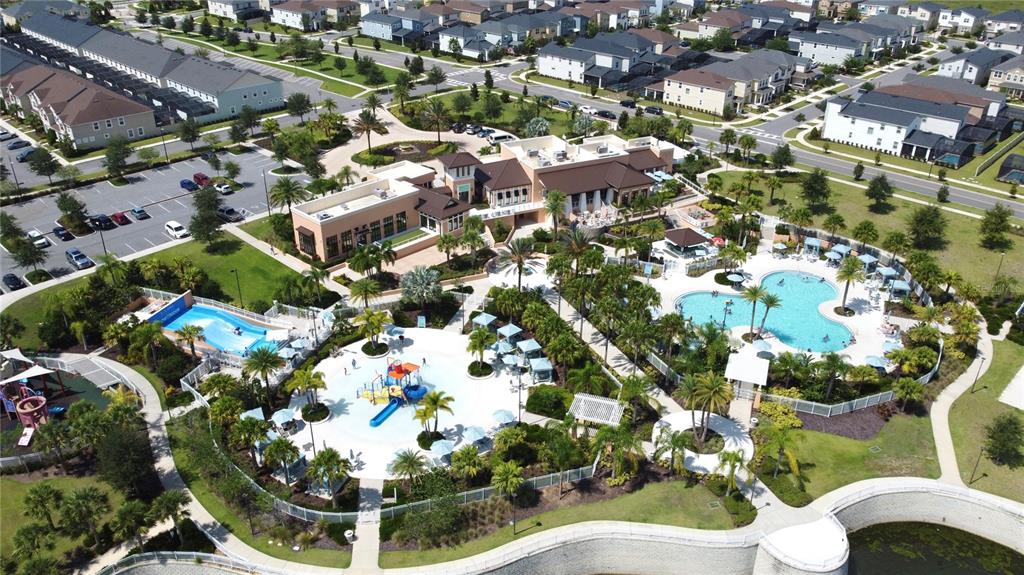 An aerial view shows a community clubhouse with a swimming pool, water slide, and parking — 1800 TROPICAL PALMS CIRCLE, KISSIMMEE, FL