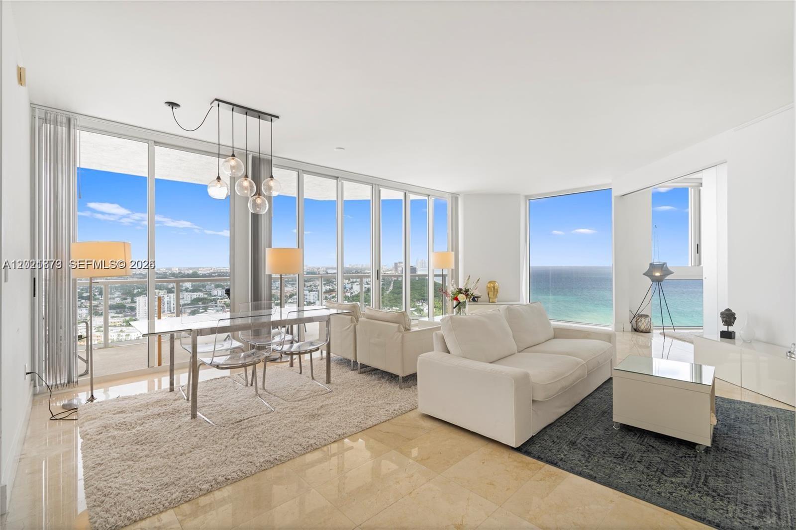 A bright living and dining area features floor-to-ceiling windows with ocean and city views — 7330 Ocean Ter # D, Miami Beach FL 33141, MIAMI BEACH, FL