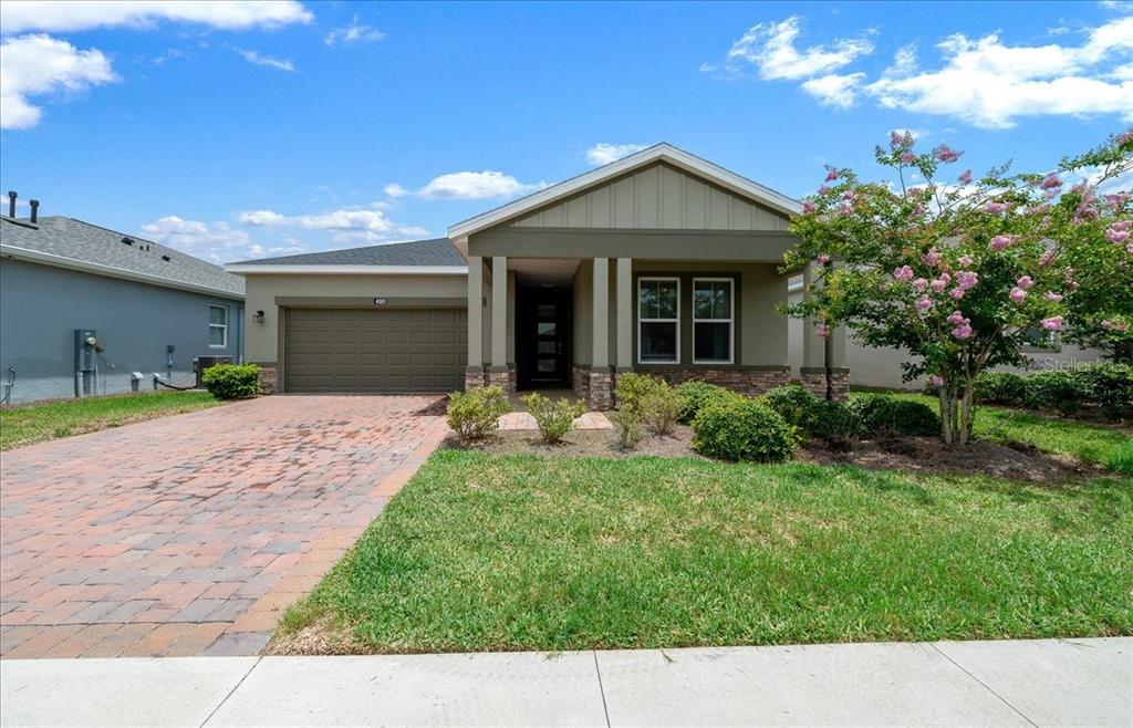 A single-story house with a brick driveway, stone accents, and a covered front porch — 4351 NW 54TH TERRACE, OCALA, FL