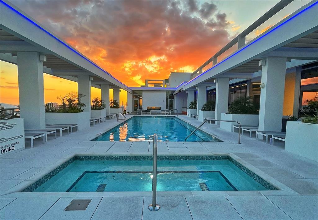 A rooftop swimming pool and hot tub at sunset with white pillars and lounge chairs — 777 3RD AVENUE N UNIT 1603, ST PETERSBURG, FL