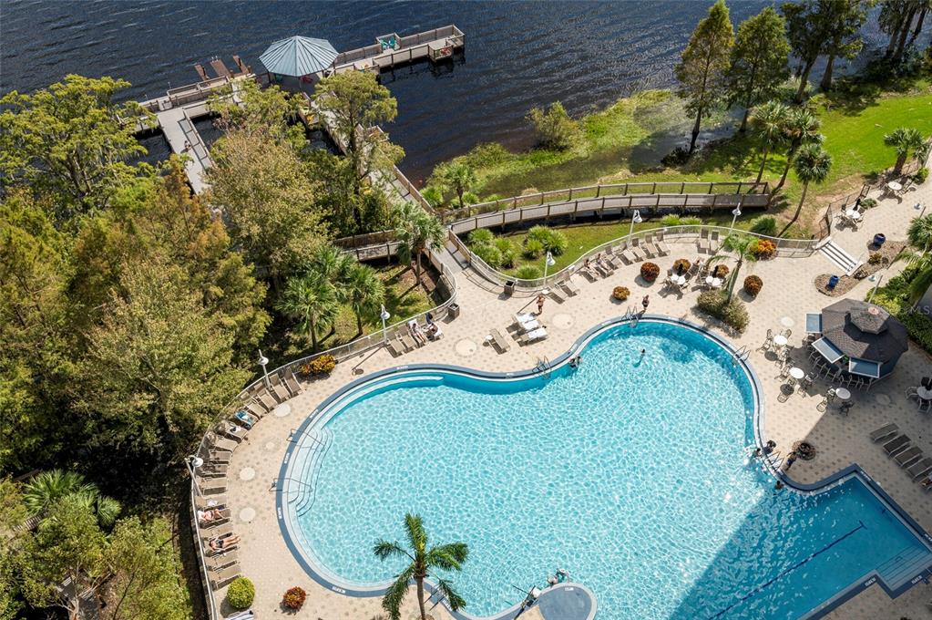 An aerial view shows a swimming pool, a wooden pier, and a gazebo by a lake — 13415 BLUE HERON BEACH DRIVE UNIT 1404, ORLANDO, FL