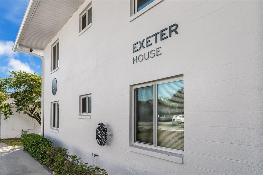 The exterior of a white, two-story apartment building labeled Exeter House with a sidewalk — 1140 S ORLANDO AVENUE UNIT E2, MAITLAND, FL