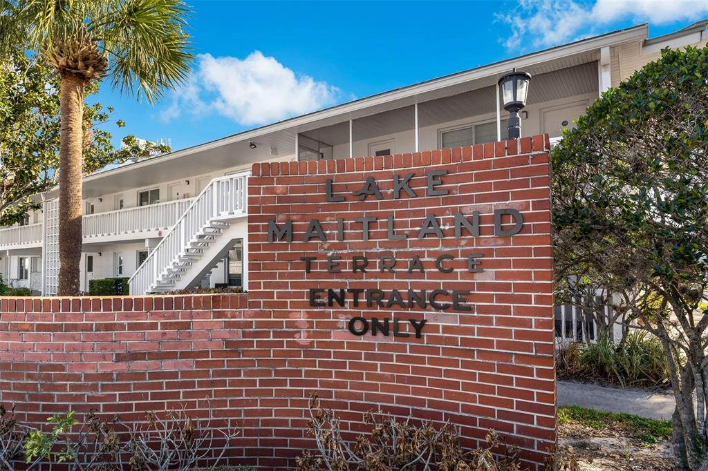 A brick sign reading Lake Maitland Terrace Entrance Only stands before a two-story apartment building — 1140 S ORLANDO AVENUE UNIT E2, MAITLAND, FL